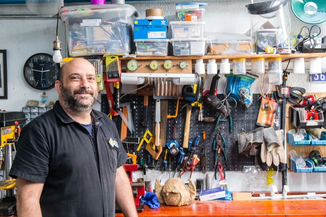 Tutor das oficinas no espaço maker do NPAS, em frente à parede de ferramentas